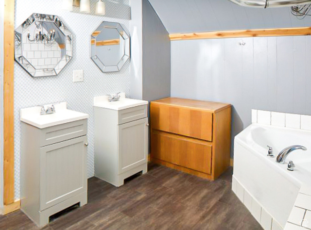 Bathroom with dual bowl vanity, a bath, and hardwood / wood-style floors