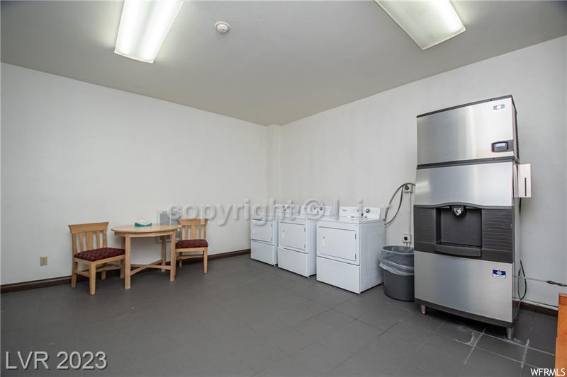 Miscellaneous room featuring dark tile flooring and independent washer and dryer