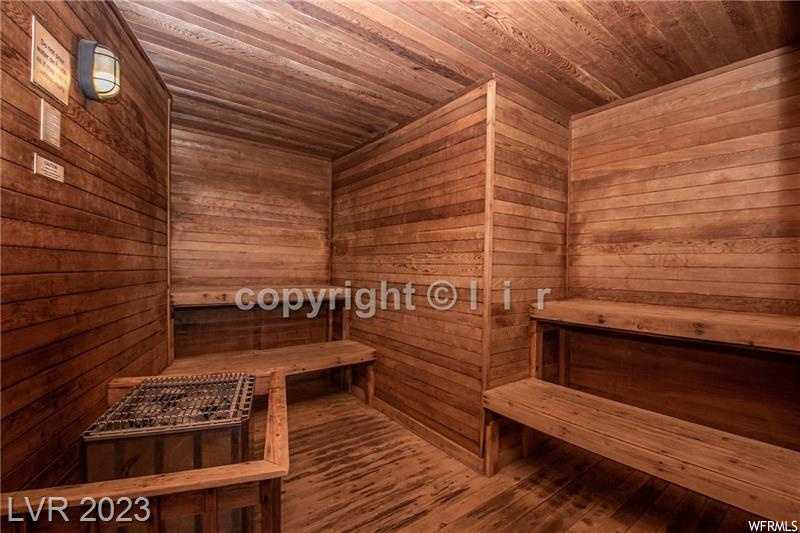 View of sauna with dark hardwood / wood-style flooring, wood walls, and wood ceiling