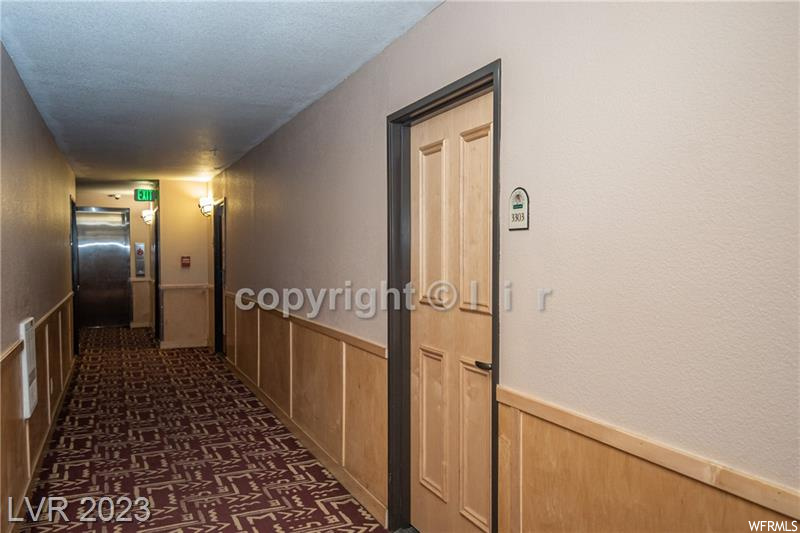 Hallway featuring dark carpet and elevator