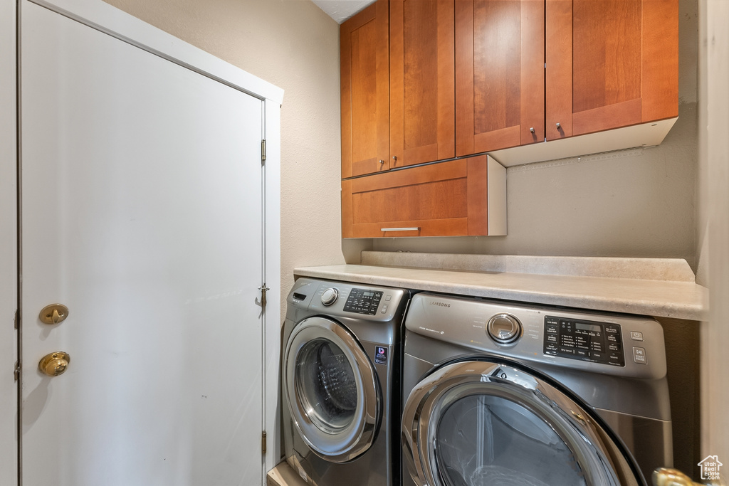 Clothes washing area with cabinets and separate washer and dryer