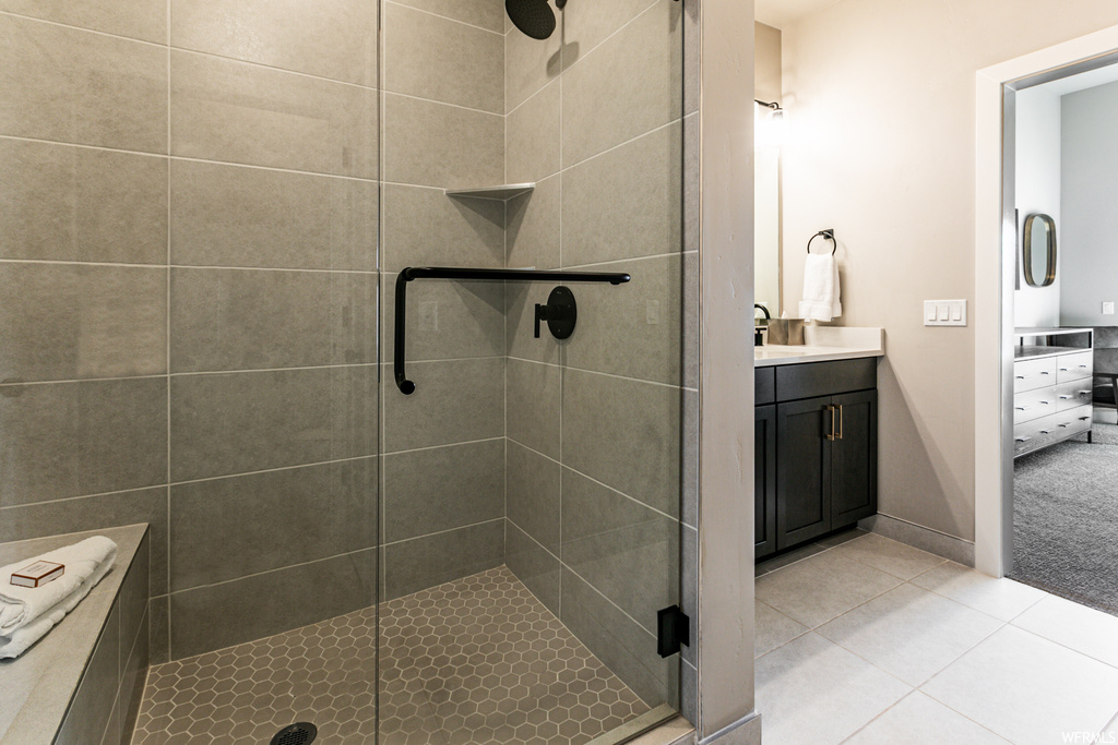 Bathroom featuring tile flooring, walk in shower, and vanity