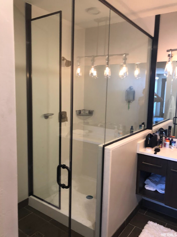 Bathroom with vanity, walk in shower, and tile floors