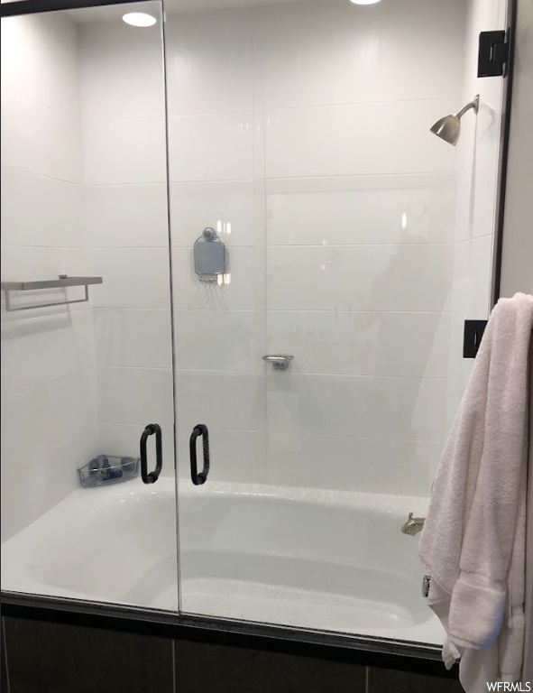 Bathroom with bath / shower combo with glass door