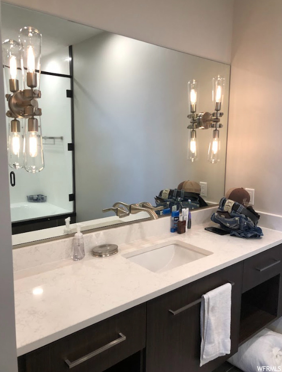 Bathroom with large vanity and a chandelier