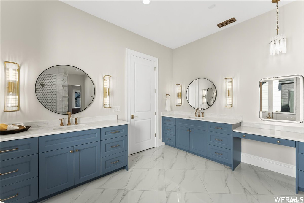 Bathroom featuring tile flooring, dual vanity, and a chandelier