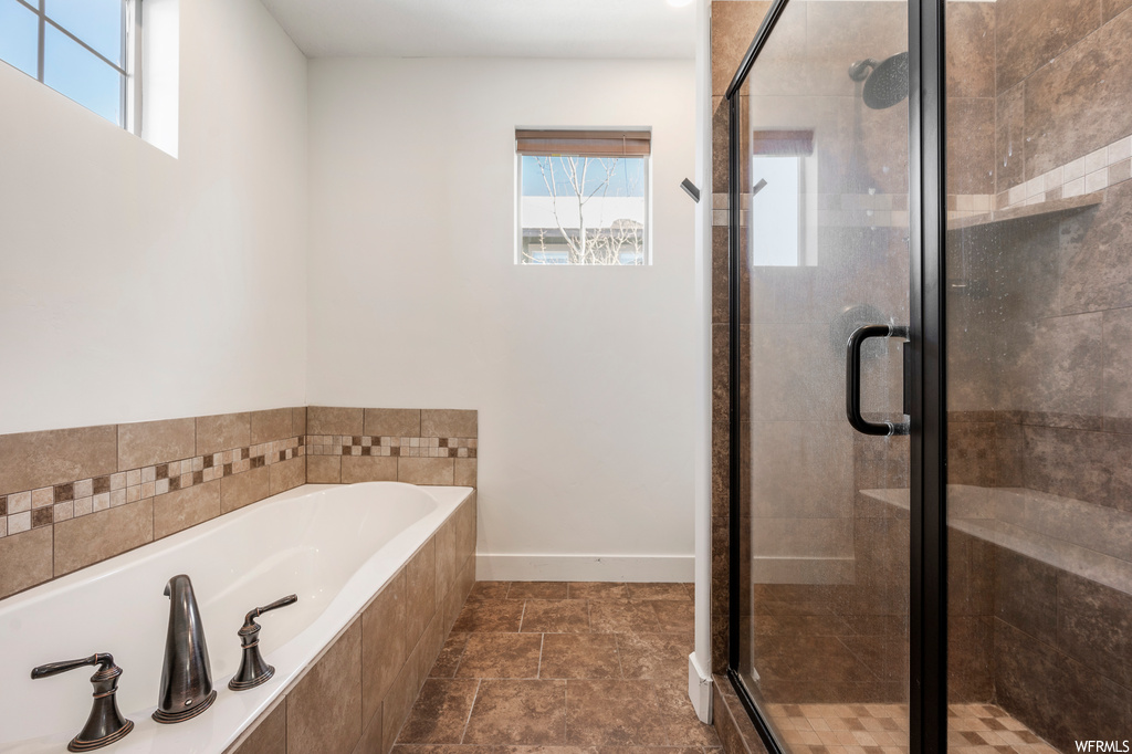 Bathroom with separate shower and tub, a healthy amount of sunlight, and tile flooring