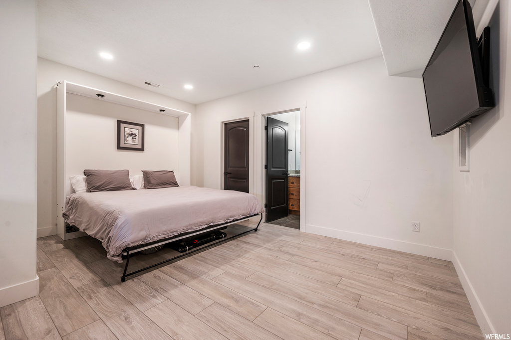 Bedroom featuring connected bathroom and light hardwood / wood-style floors