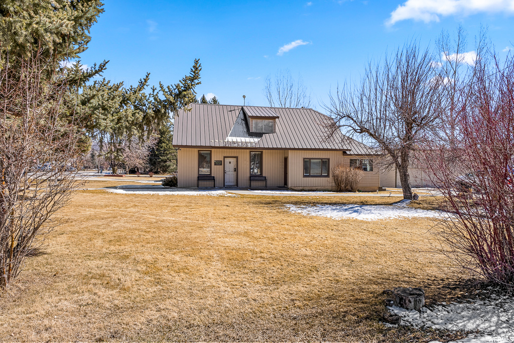 Rear view of property with a lawn
