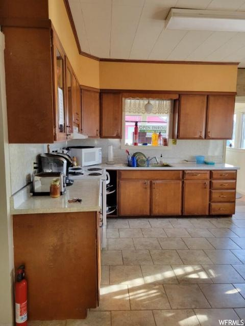 Kitchen featuring light tile floors, sink, and backsplash