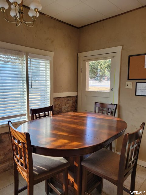 Dining space featuring light tile floors and a notable chandelier
