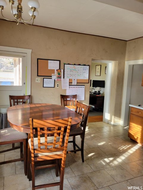 Tiled dining room featuring a notable chandelier