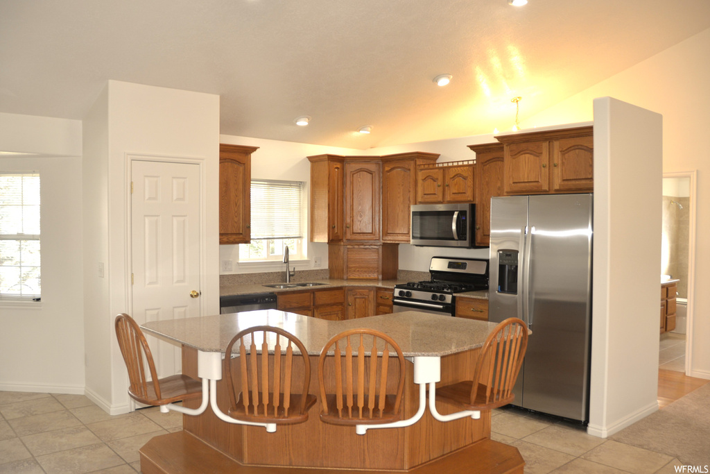 Kitchen featuring a healthy amount of sunlight, a kitchen island, and appliances with stainless steel finishes