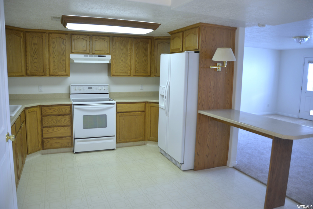 Kitchen featuring white appliances and light tile flooring