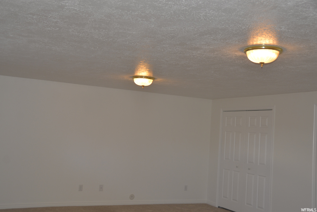 Unfurnished room featuring a textured ceiling