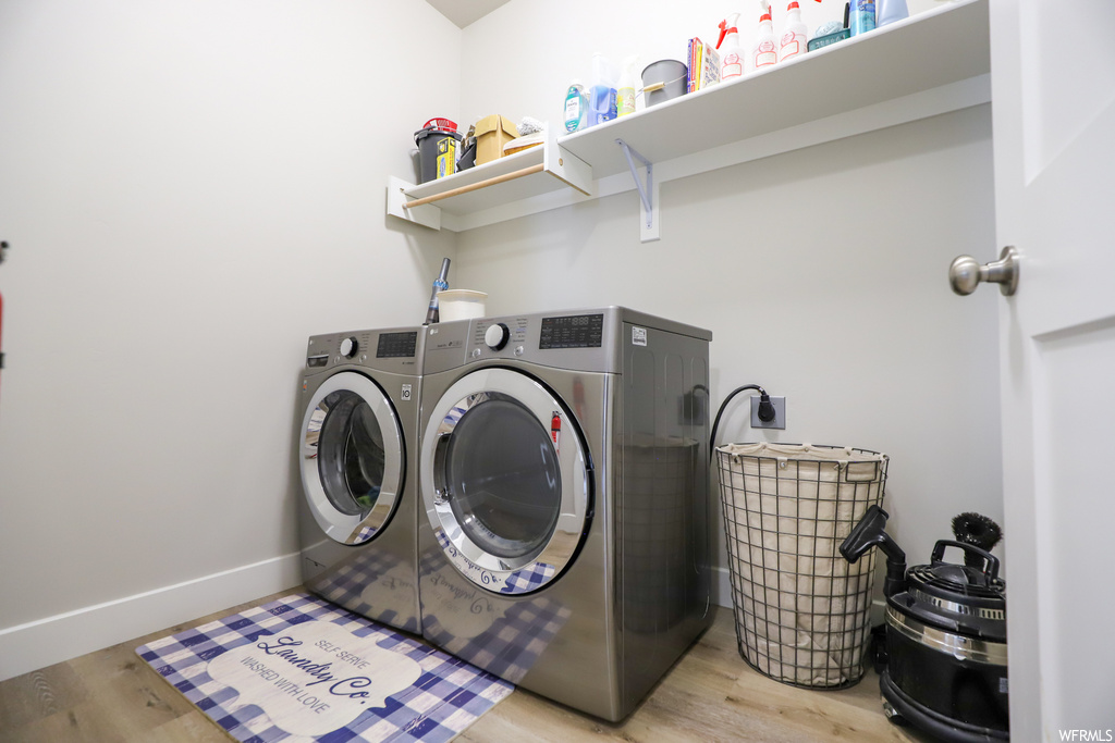 Laundry area featuring independent washer and dryer and light wood-type flooring