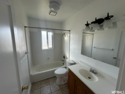Full bathroom featuring toilet, tile floors, shower / tub combination, and vanity with extensive cabinet space