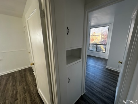 Corridor featuring dark wood-type flooring
