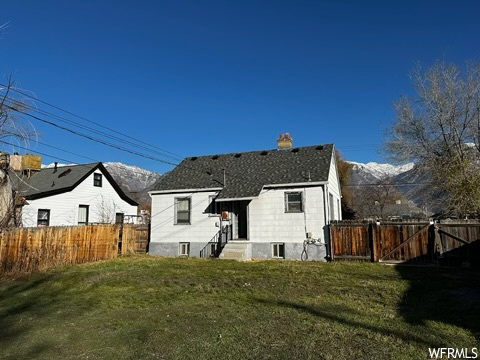 Rear view of property with a yard and a mountain view