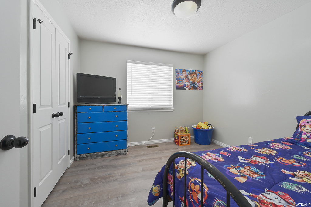 Bedroom with light hardwood / wood-style flooring