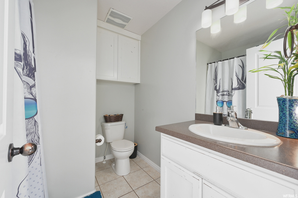 Bathroom featuring toilet, tile flooring, and oversized vanity