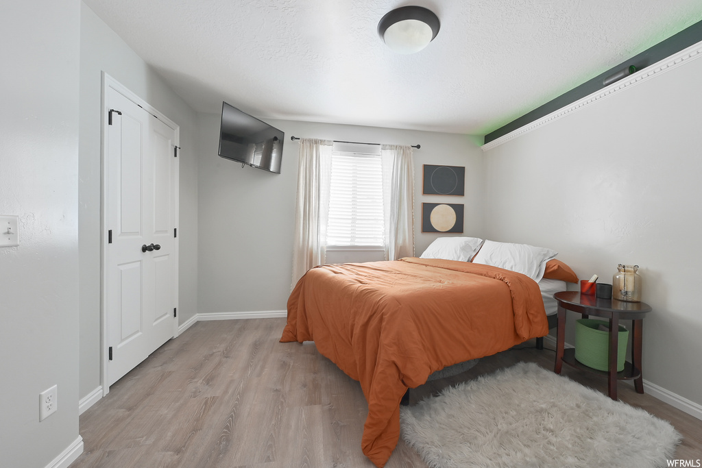 Bedroom featuring light wood-type flooring and a closet