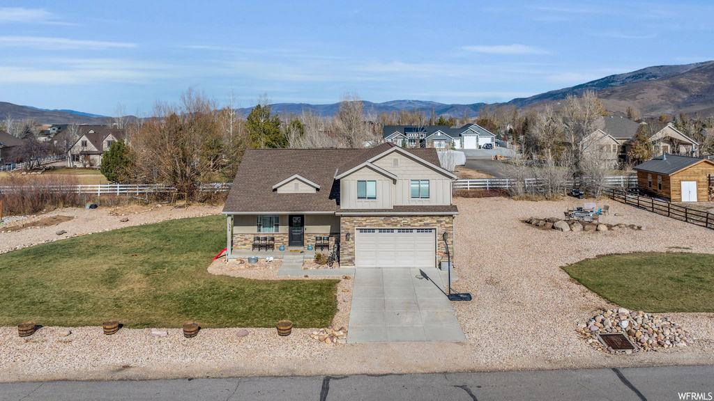 View of front facade with a garage and a mountain view