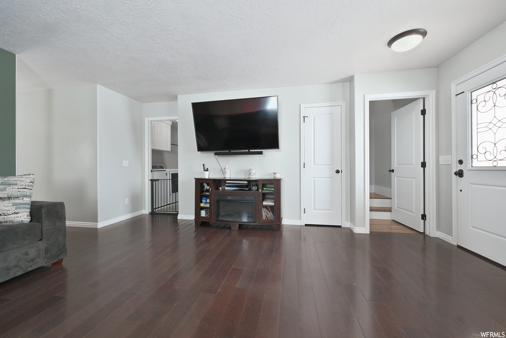 Living room featuring dark hardwood / wood-style floors and a textured ceiling