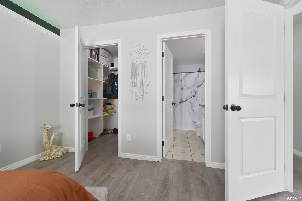 Bedroom featuring ensuite bathroom, a closet, and light tile floors