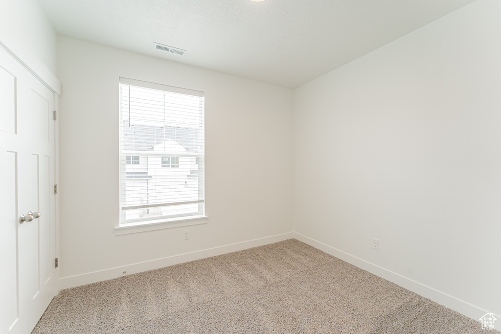 Unfurnished room with plenty of natural light and light colored carpet