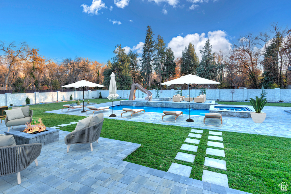 View of yard with a fenced in pool, an outdoor fire pit, and a patio area