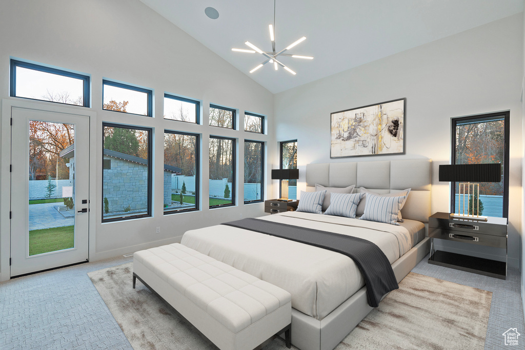 Bedroom featuring multiple windows, an inviting chandelier, light colored carpet, and high vaulted ceiling
