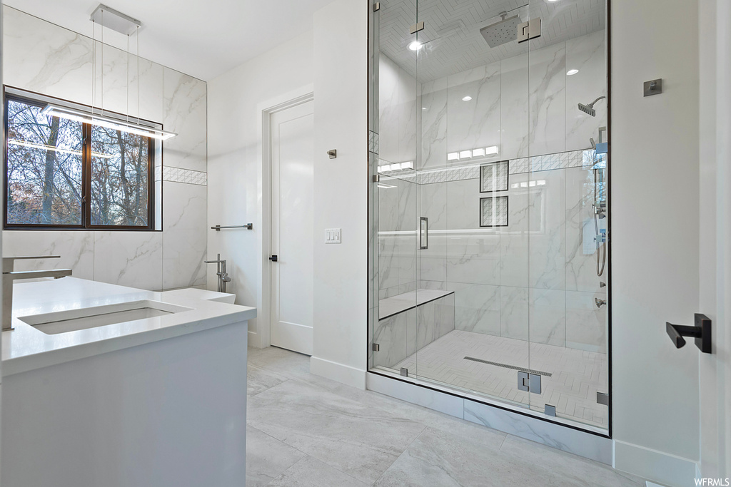Bathroom with vanity, tile floors, tile walls, and an enclosed shower
