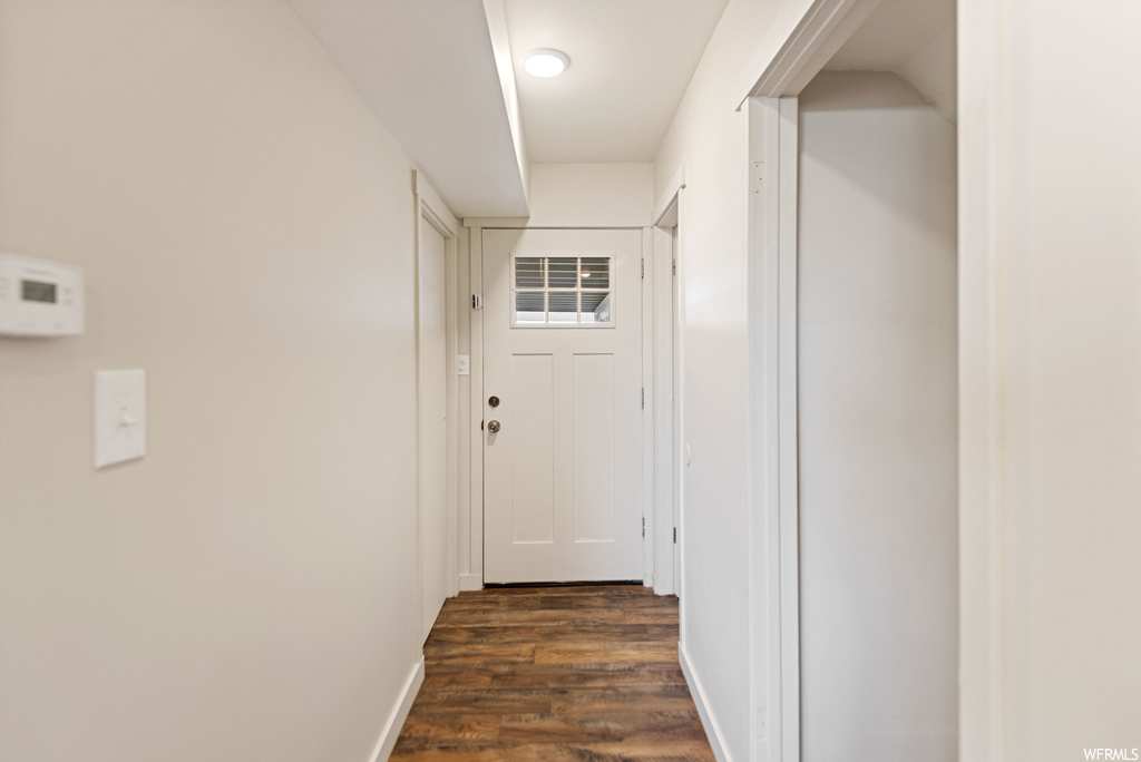 Hallway with dark hardwood / wood-style flooring