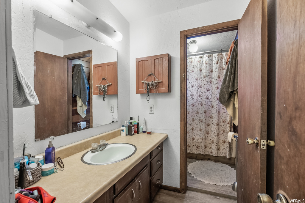 Bathroom featuring oversized vanity and hardwood / wood-style floors