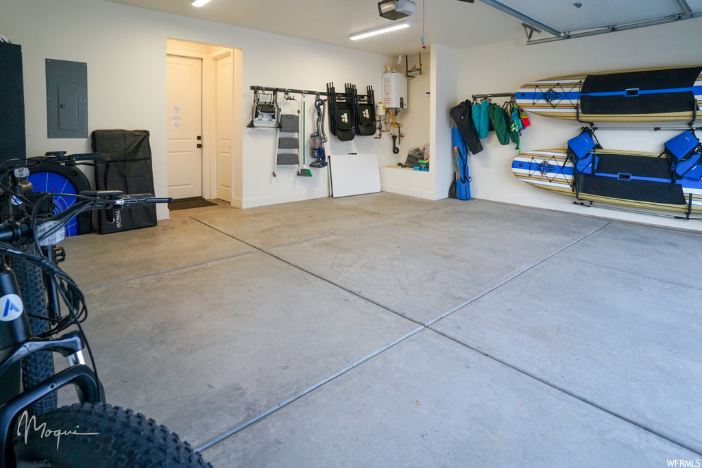 Garage featuring a garage door opener and tankless water heater