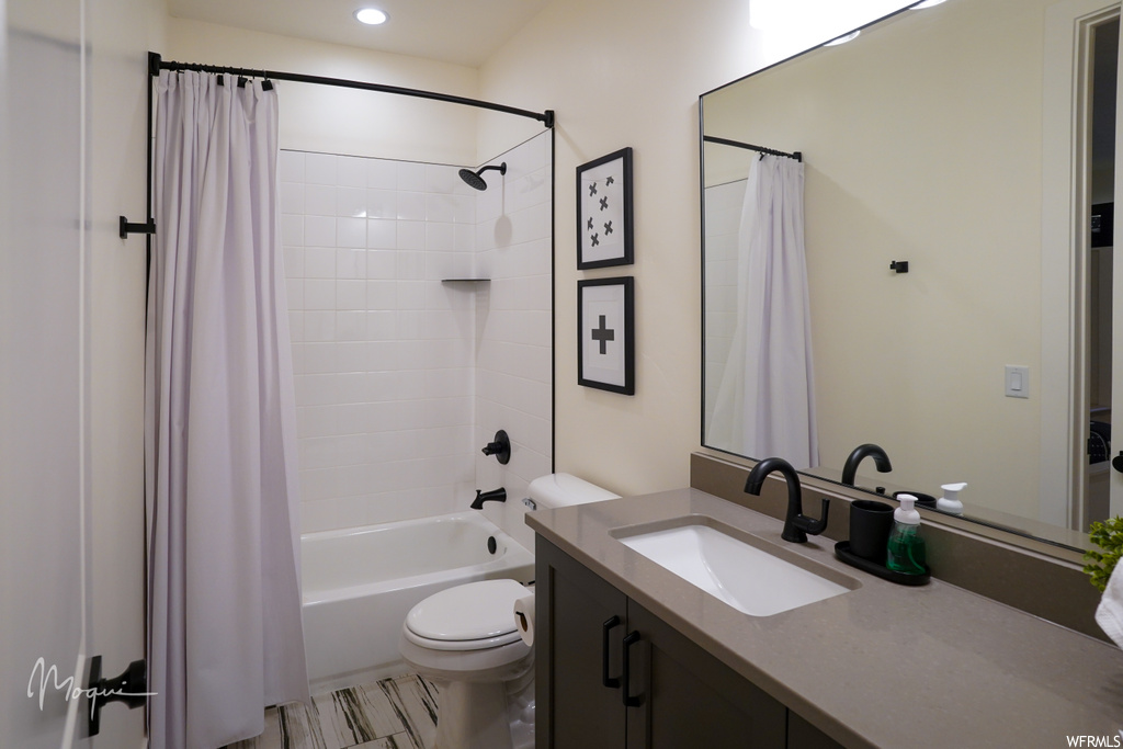 Full bathroom featuring toilet, tile floors, shower / bath combo, and oversized vanity