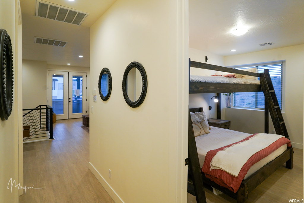Bedroom featuring french doors, access to exterior, and light hardwood / wood-style floors