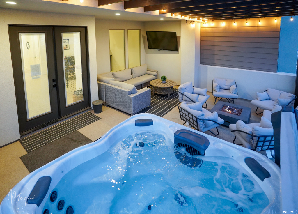 Exterior space featuring an outdoor living space, a hot tub, and french doors