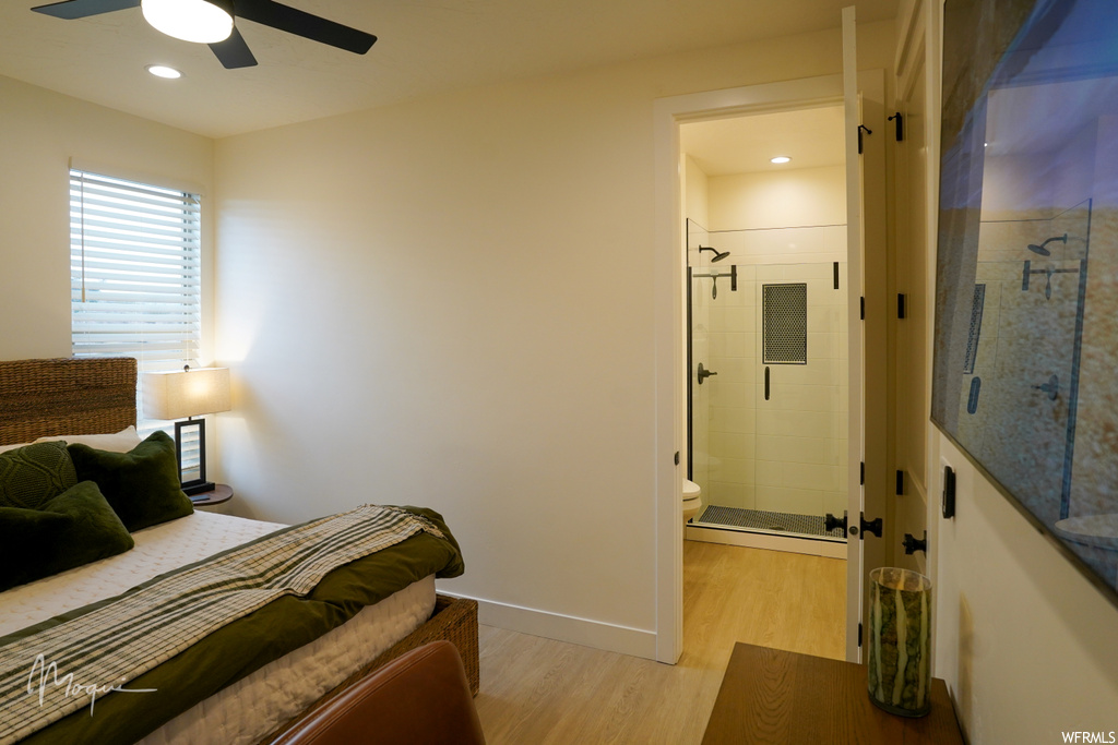 Bedroom with connected bathroom, light wood-type flooring, and ceiling fan