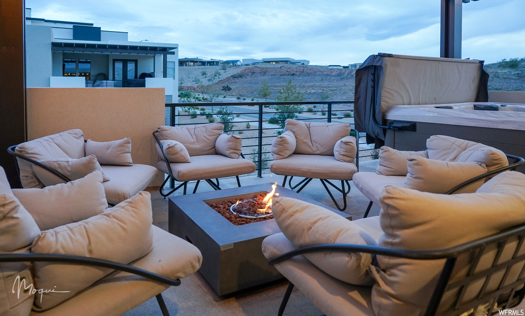 View of terrace with an outdoor living space with a fire pit and a balcony