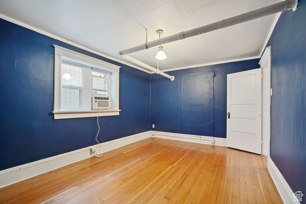 Spare room with ornamental molding and light hardwood / wood-style flooring