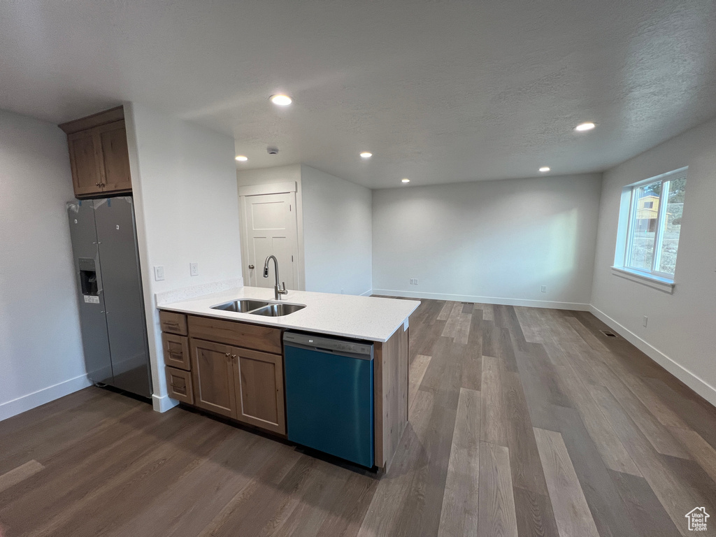 Kitchen with dishwashing machine, light hardwood / wood-style floors, refrigerator, and sink