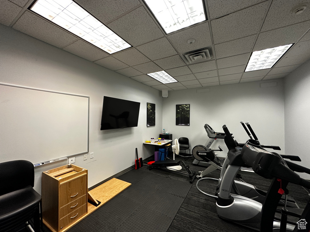 Workout room with a paneled ceiling and carpet flooring