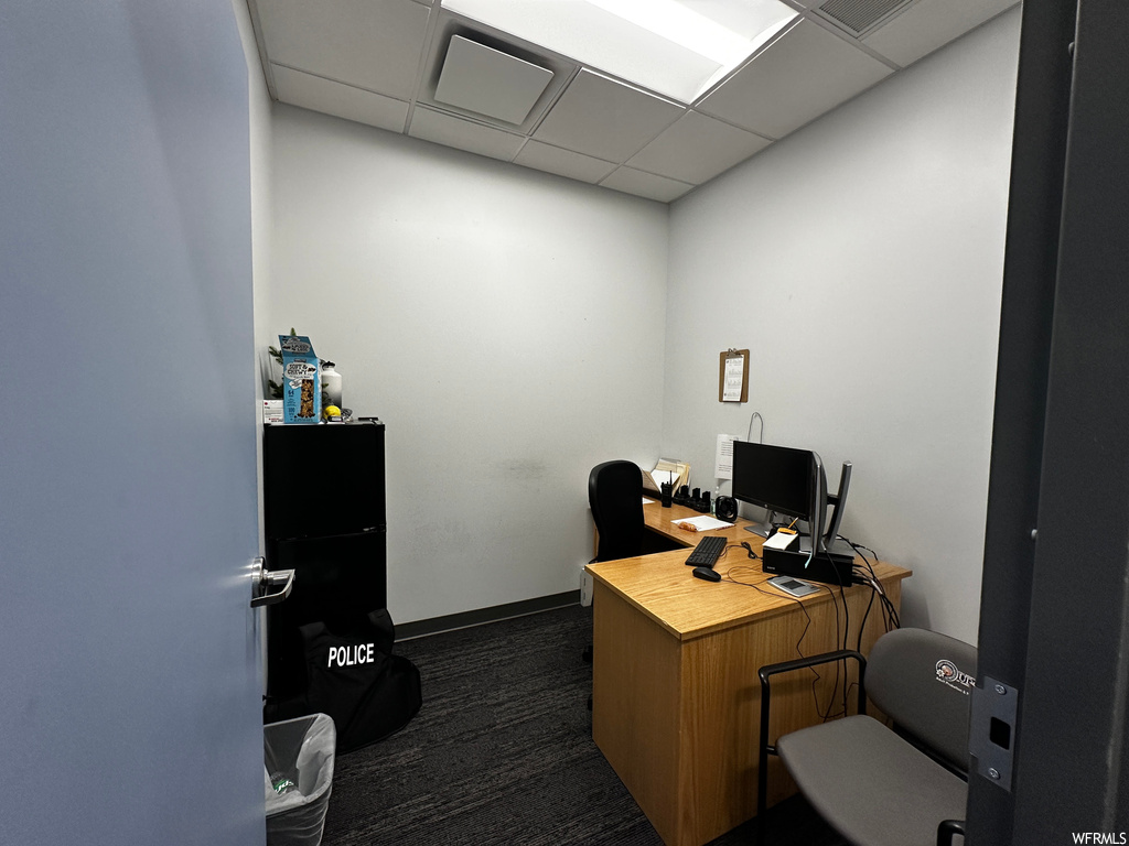 Office area with dark carpet and a drop ceiling