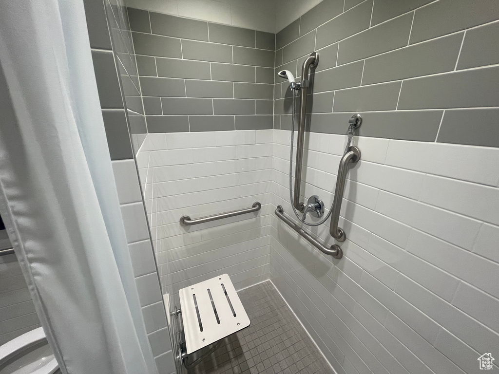 Bathroom view of tiled shower and toilet