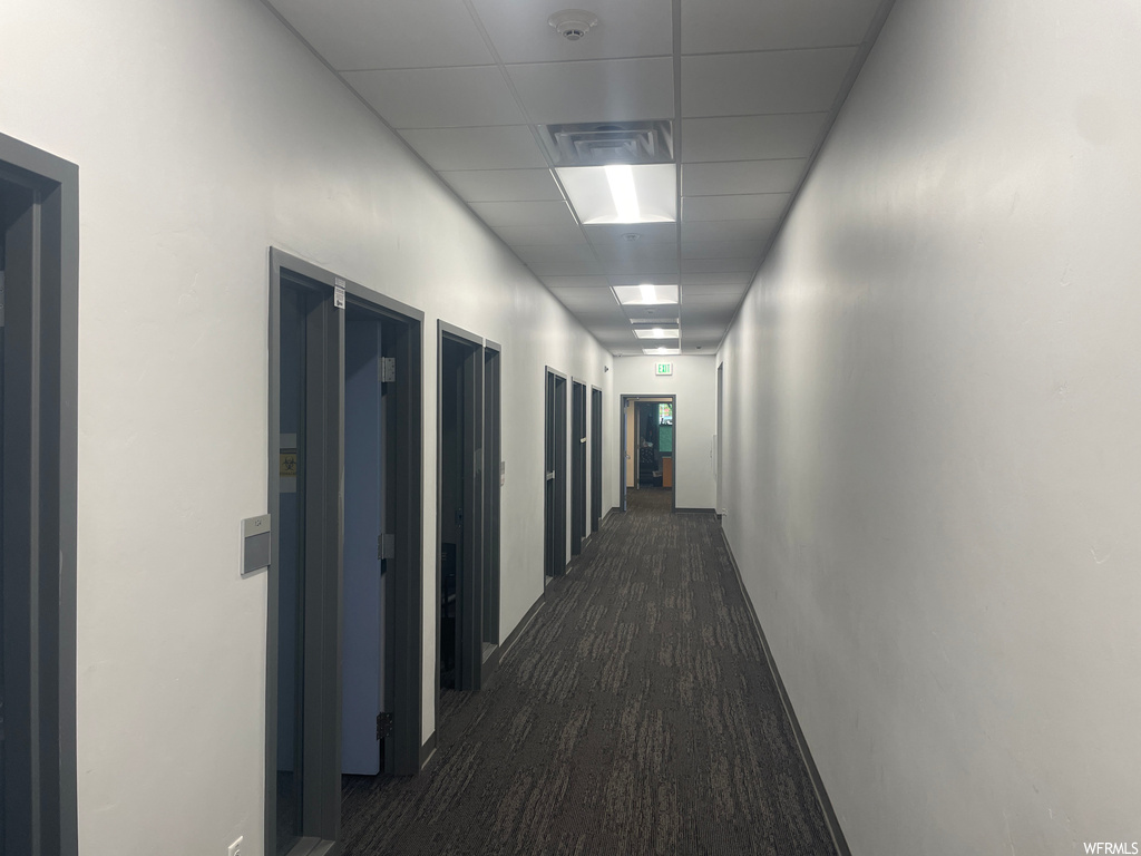 Hallway featuring a drop ceiling and elevator