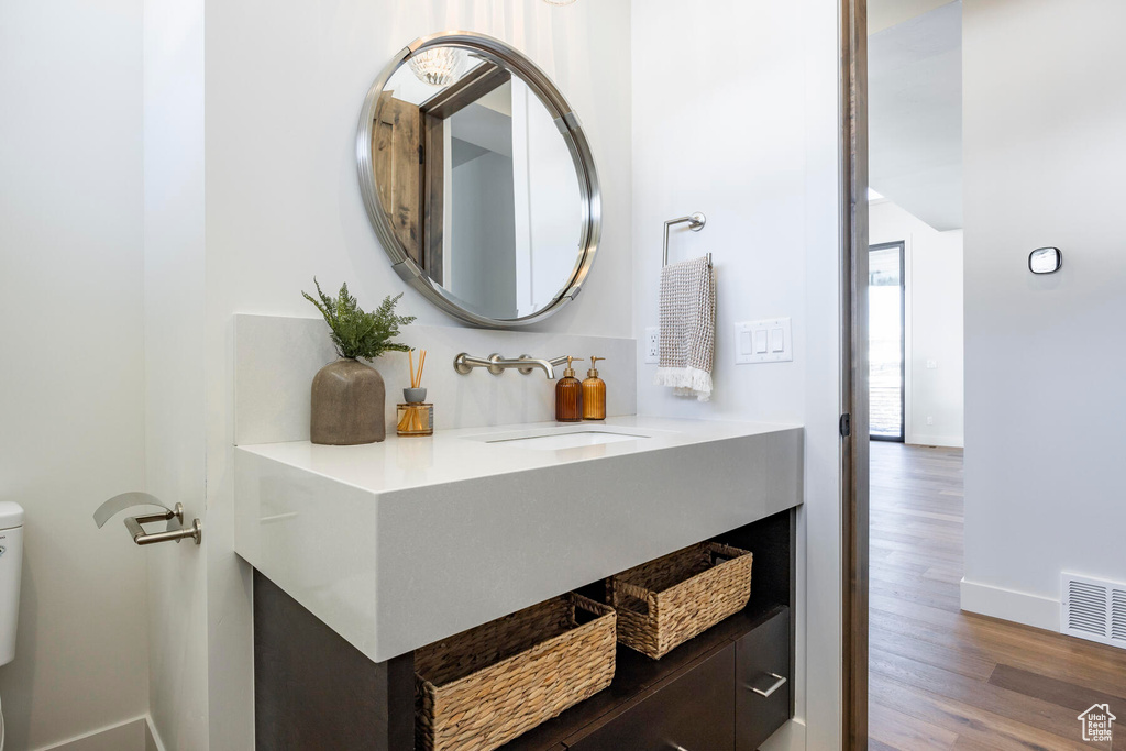 Bathroom featuring vanity, toilet, and wood-type flooring