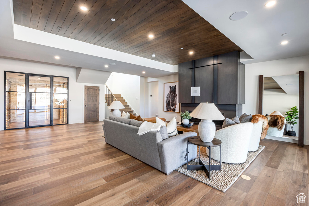 Living room featuring a barn door, light hardwood / wood-style floors, and wood ceiling