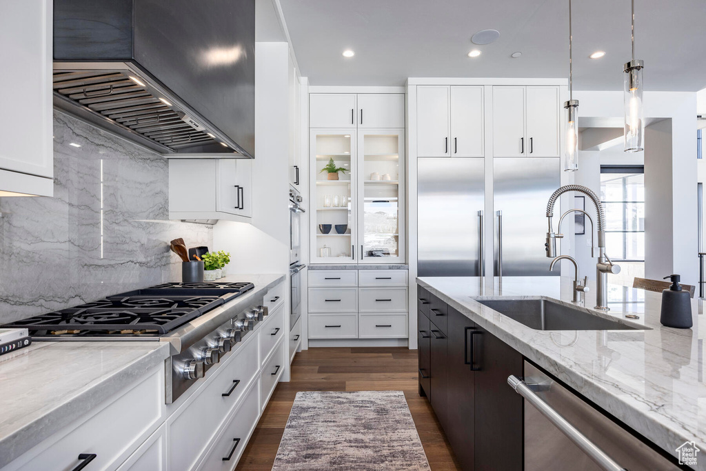 Kitchen with white cabinets, decorative light fixtures, dark hardwood / wood-style flooring, tasteful backsplash, and custom exhaust hood